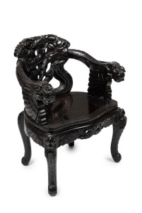 An antique Chinese chair, ebonized finish with carved dragon motif, early 20th century, 84cm high, 63cm across the arms