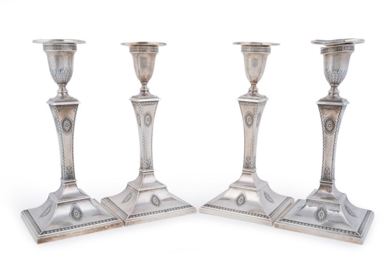 Four English sterling silver candlesticks by Goldsmiths & Silversmiths Co. of London, circa 1913, and John & William Deakin of London, ​circa 1902, encased and weighted bases, 24cm high