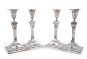 Four English sterling silver candlesticks by Goldsmiths & Silversmiths Co. of London, circa 1913, and John & William Deakin of London, circa 1902, encased and weighted bases, 24cm high
