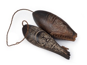 Two Marupai magic charms, carved wood with remains of piped clay and natural fibre string, Papuan Gulf, 13cm and 12cm long