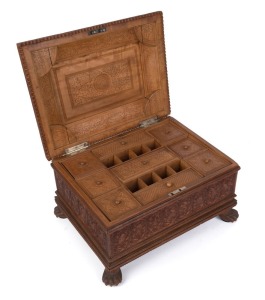 An Anglo-Indian workbox, superbly carved on all sides, with claw feet and compartmented lift out tray fitted with lids, early to mid 19th century, 18cm high, 32.5cm wide, 25.5cm deep