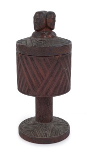 Maori wooden cup and cover, superbly carved with three headed finial bearing full Moko (facial tattoos), inlaid with paua shell decoration, 19th century, 25cm high