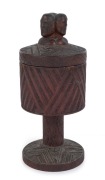 Maori wooden cup and cover, superbly carved with three headed finial bearing full Moko (facial tattoos), inlaid with paua shell decoration, 19th century, 25cm high