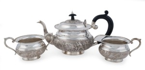 An antique Indian silver three piece tea service with elephants and farming scenes, 19th century, stamped "SILVER", the teapot 17cm high, 30cm wide, 1,364 grams total