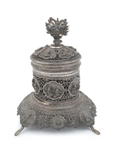 An antique Burmese silver Betel box and cover with stand, finely pierced and chased on all sides with figural finial, 19th century, 19cm high, 430 grams