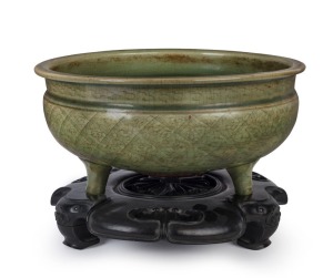 A large antique Chinese celadon porcelain censer with incised geometric design resting on three feet with a finely carved timber stand, Ming Dynasty 14th/15th century. 23cm high overall, 33.5cm diameter. PROVENANCE: Private Collection Melbourne with JOSHU