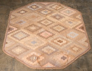 An antique American quilt/table cover, hand-stitched with mauve silk backing, 19th century, ​158cm wide