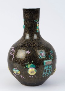 A Chinese spherical porcelain vase with polychrome glaze on black ground decorated with Chinese treasures, Republic period, underglaze blue six character Qianlong mark, ​34cm high