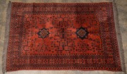 An Afghan hand-knotted wool rug with terracotta background, 152 x 98cm