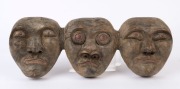 A three-faced tribal mask, carved wood with remains of painted finish, 19cm high, 52cm wide