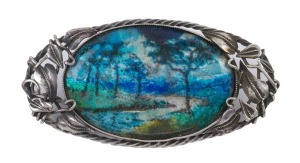 GEORGE HUNT (attributed) English enamel brooch with landscape scene, set in silver with entwined foliate design, circa 1920s, retailed and stamped by "SARGISON, SILVER, HOBART", 5cm wide