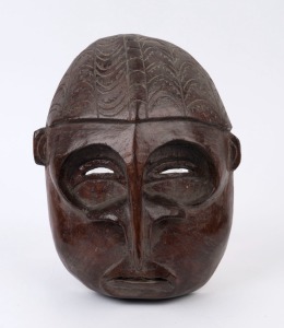 A tribal mask, carved and lacquered wood, African origin, 29cm high