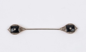An Art Deco tie pin, yellow gold and silver set with onyx and diamonds, circa 1920, ​​​​​​​7.5cm wide