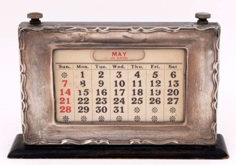 A sterling silver desk calendar, made in Sheffield, circa 1902, ​​​​​​​12cm high, 21cm wide