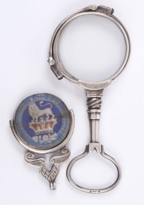 George V enamelled shilling fob together with a silver lorgnette, 19th and early 20th century, (2 items),