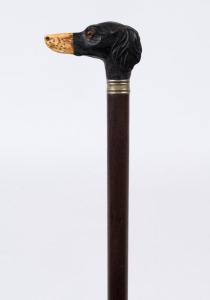 An antique walking stick with carved ebony and bone dog's head handle, silver collar, timber shaft and brass ferrule, 19th century, ​​​​​​​81cm high