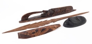 Four assorted tribal artefacts including two Papua New Guinea masks, a spear tip and a bamboo carving, the largest 87cm long