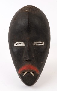 A tribal mask, carved wood, fabric and metal, African origin, 20th century, ​24cm high