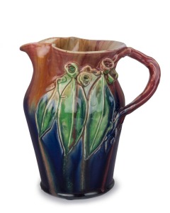 REMUED pottery jug with applied gumnuts, leaves and branch handle, early pink, lime green and blue colourway, incised "Remued, Hand Made, 54LM", 25cm high