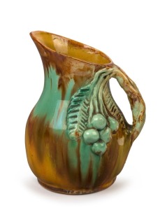 UNA DEERBON green and brown glazed pottery jug with applied branch handle, leaves and fruit, incised "Una Deerbon", 19cm high