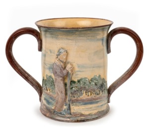 REMUED "Batman, Melbourne Centenary" rare pottery two-handled cup with applied figure in landscape, incised "This Is The Place For A Village", signed "Remued", 15cm high, 22cm wide