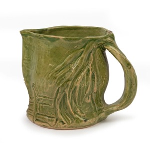 MERRIC BOYD green glazed pottery jug with windswept branch handle and sgraffito farm landscape decoration, incised "Merric Boyd, Gumtree", 12cm high, 15cm wide