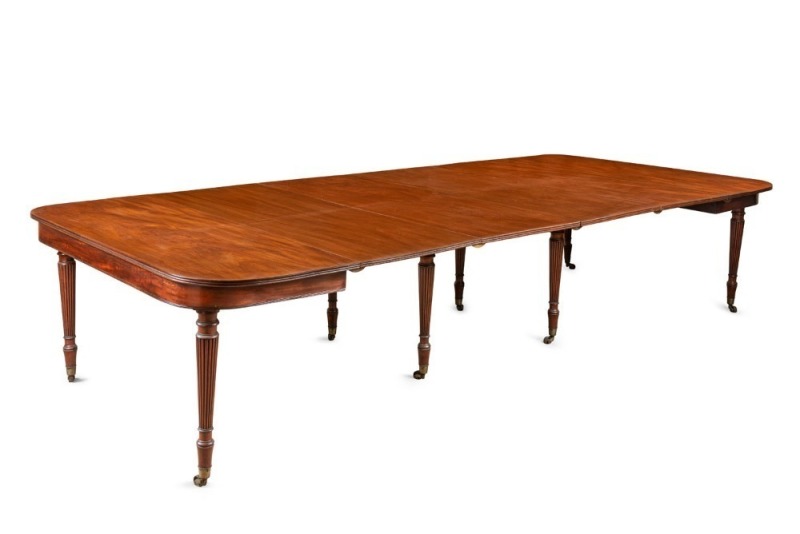 GILLOWS superb English George III D-end banquet table, Cuban mahogany with four extension leaves, recessed aprons to the ends, supported on eight finely turned and tapered, reeded legs each terminating in original brass castors, circa 1820, 72.5cm high, 3