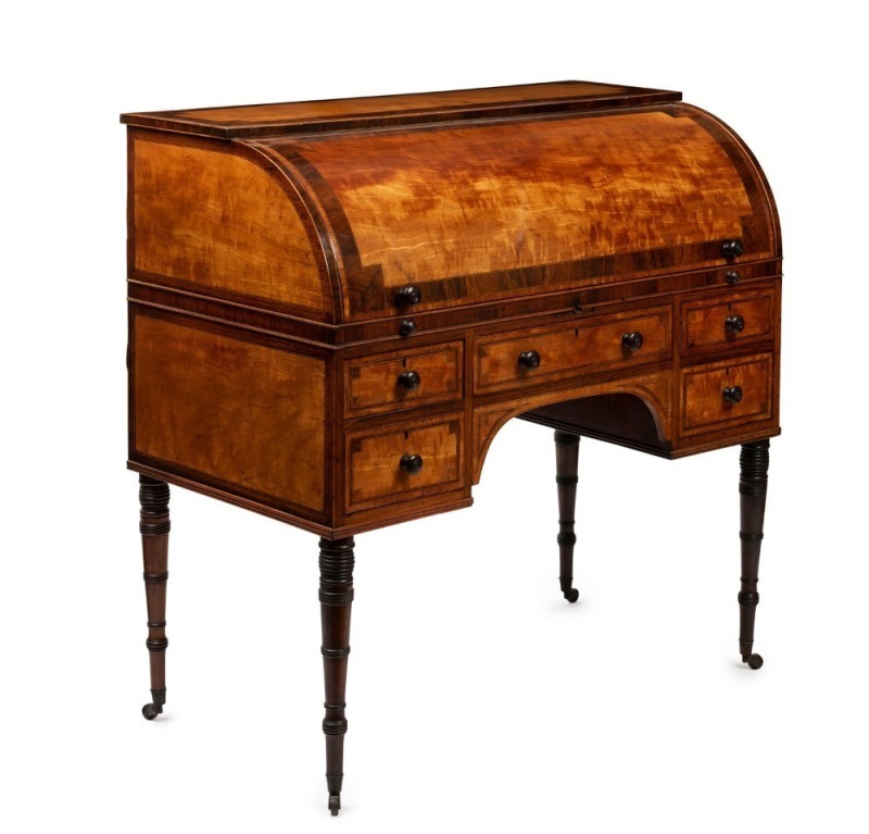 A stunning antique English cylinder roll-top desk, superbly crafted in satinwood with rosewood cross-banding and parquetry decoration, interior fitted with secretaire and compartments, turned and tapered simulated rosewood legs terminating in original bra