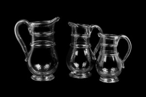 A graduated set of three antique English glass ale jugs, circa 1820, the largest 27.5cm high