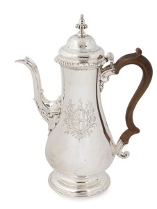 A George III English sterling silver coffee pot. A very fine example with engraved armorial crest and attractive serpentine tapering spout with an oval scalloped mount. Heavy gadrooned top rim and a circular high raised double domed cover with stylized acorn finial, plus original ebony handle. Made by Thomas Whipman and Charles Wright of London, circa 1764, 28cm high, 780 grams total
