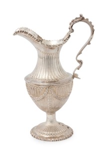 A George III English sterling silver milk jug of fine classical form, adorned with swags over fluted decoration. Finely shaped handle and gadrooned rim and foot. Made by James Beebe of London, circa 1811, 17.5cm high, 222 grams