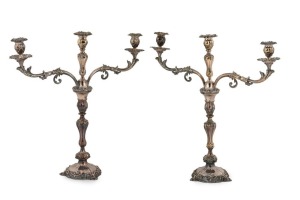  A fine pair of Sheffield plate three branch candelabra with Rococo repoussé decoration on circular bases terminating in stylized shell feet. London, circa 1860. 55cm high