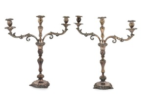 A fine pair of Sheffield plate three branch candelabra with Rococo repoussé decoration on circular bases terminating in stylized shell feet. London, circa 1860. 55cm high
