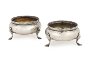 A pair of sterling silver table salts in the Georgian style; each of bowl form terminating in three raised feet. Made by Charles Stuart Harris of London, circa 1890, 90 grams total
