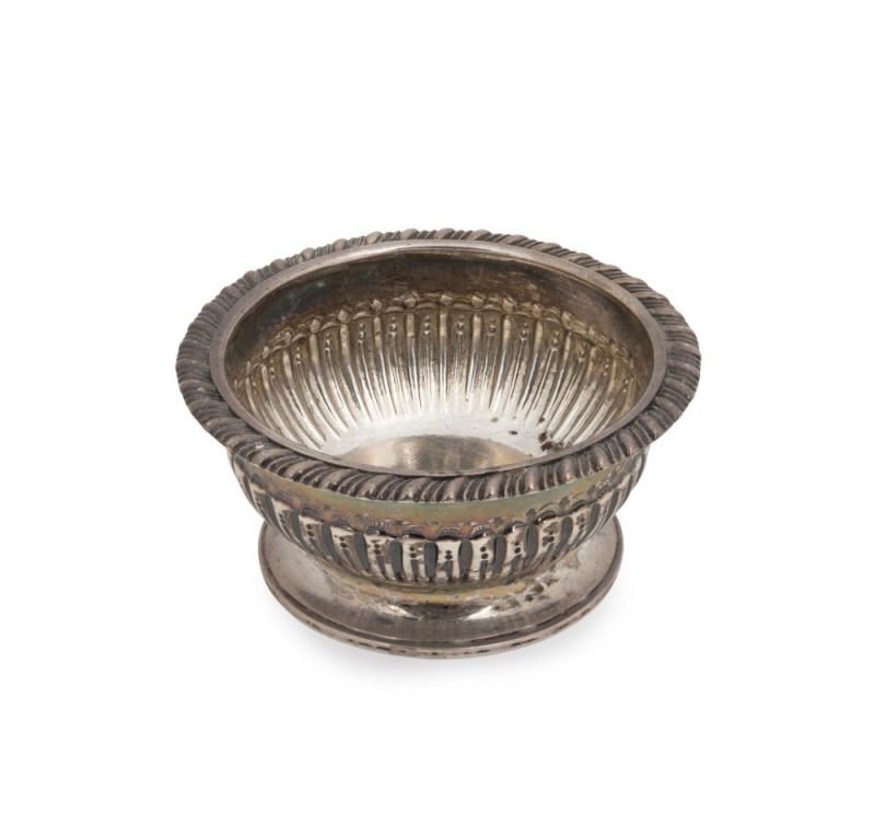 A Georgian sterling silver table salt cellar with gadrooned rim and reeded body on a circular foot. Made in London, circa 1810, 4cm high 62 grams.
