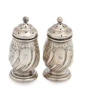 A pair of antique English sterling silver pepper pots in the early Georgian manner with gadrooned reeding and foliate embossed decoration. By Deakin & Francis of Birmingham, circa 1891, 7cm high, 80 grams total