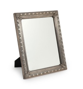 An Argentinian table mirror in a 925 silver frame with raised decoration and applied floral corner mounts, 20th century, 43 x 35cm.