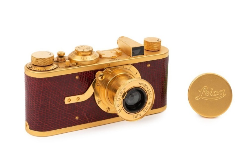 LEITZ: Leica "Luxus" Gold Plated Replica [#23355], red lizard skin body cover, fitted with Elmar f3.5 50mm lens and matching lens cap, with matching Leica leather ERC.