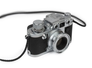 A Steiff-Club "Classic 1909 Teddy Bear 43", faux hair with photographers outfit, Leica cap and Minoctar Leica III f miniature by Minox.