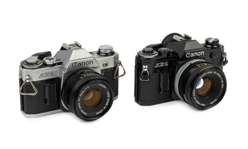 Canon AE-1 SLR cameras: one with black finish [#911428] and