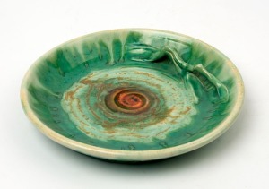 REMUED green and orange glazed pottery platter with applied branch, incised "Remued 91S", 22.5cm diameter