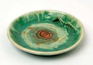 REMUED green and orange glazed pottery platter with applied branch, incised "Remued 91S", 22.5cm diameter