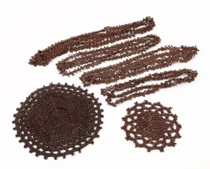Four appleseed necklaces and two placemats, 20th century, (6 items), the largest necklace 155cm long