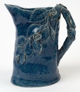 ARTIST UNKNOWN hand-built blue glazed pottery jug with applied rose and wheat decoration, incised signature to base (illegible), 18cm high - 2