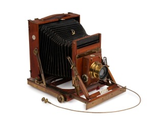 Thornton-Pickard: New Imperial Triple Extension half plate field camera, mahogany with Brass trim and strips above and below Rollerblind shutter, with leather bellows, circa 1910, with Beck Symmetrical lens and original cable release. Baker and Rouse (Col
