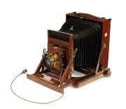 Thornton-Pickard: New Imperial Triple Extension half plate field camera, mahogany with Brass trim and strips above and below Rollerblind shutter, with leather bellows, circa 1910, with Beck Symmetrical lens and original cable release. Baker and Rouse (Col - 2