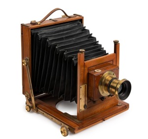 Thornton-Pickard: Amber compact folding view half plate camera (S 69305 impressed on base of shutter), circa 1899, brass bound lens and Harrington & Co., Sydney retailer's plate with additional plate "Harrington's Favorite Outfit"