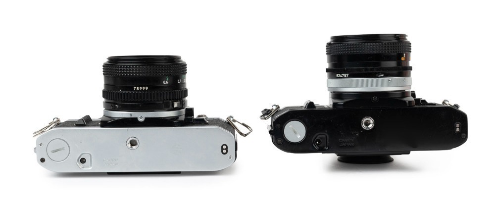 Canon AE-1 SLR cameras: one with black finish [#911428] and