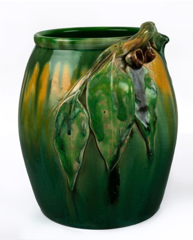 REMUED barrel shaped pottery vase with applied gumnuts and leaves, glazed in green and yellow, incised "Remued, Hand Made 114/8M", ​​​​​​​22.5cm high