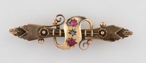 An antique 9ct gold bar brooch set with two red stones, late 19th century, ​​​​​​​5cm wide, 2.6 grams